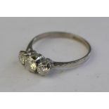 A three-stone brilliant cut diamond ring in white metal claw settings stamped plat,