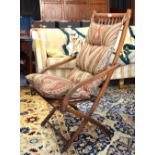 A late 19th century Liberty style folding campaign armchair c/w fabric cushions