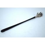 A back-scratcher with silver hand on ebony long handle, maker WW,