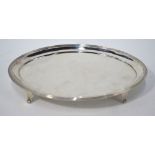 A George III silver teapot stand of elliptical form with reeded rim and scroll feet,
