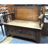 A 19th century oak monks bench converting to a table, over a box seat in the 17th century style,