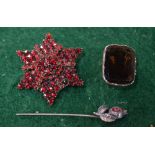 A garnet set star brooch to/w a smoky quartz foil backed brooch Condition Report