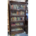 An oak five section Globe Wernicke bookcase with lead glazed doors, raised on a deep plinth base,