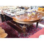 A large Victorian mahogany extending dining table having demi-lune ends and with two wide,