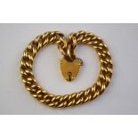 A yellow gold curb bracelet with padlock attached,