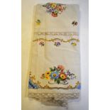 A natural linen ground tablecloth embroidered with coloured floral sprays with crocheted insets and