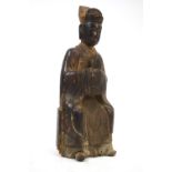 A Chinese wood sculpture of a Chinese Scholar, holding a status Badge of office, 28cm high,