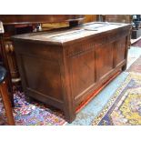A 17th/18th century oak coffer with arched moulded detail over a triple panelled front on stile