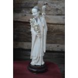 A Chinese carved ivory large figure of an ancient with dragon staff and floral sprig,