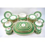 A Victorian Copeland dinner service having a with a wide green band and gilt borders with a central