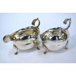 A pair of George III silver pot-bellied sauce boats with cut rims, scroll handles and hoof feet,