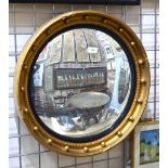 A Regency style giltwood and ebonised circular convex mirror,
