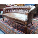 A Victorian walnut framed button upholstered brown leather small sofa,