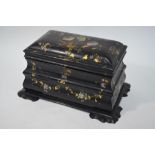 A black papier mache tea caddy of sarcophagus form, with mother of pearl inlaid,