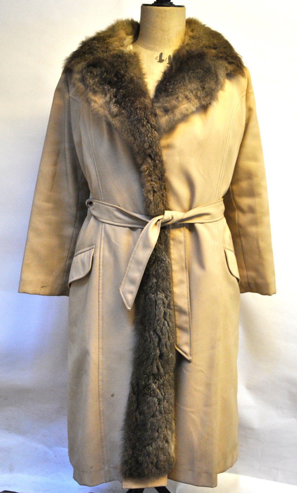 A cream fur-lined coat with tie-belt,