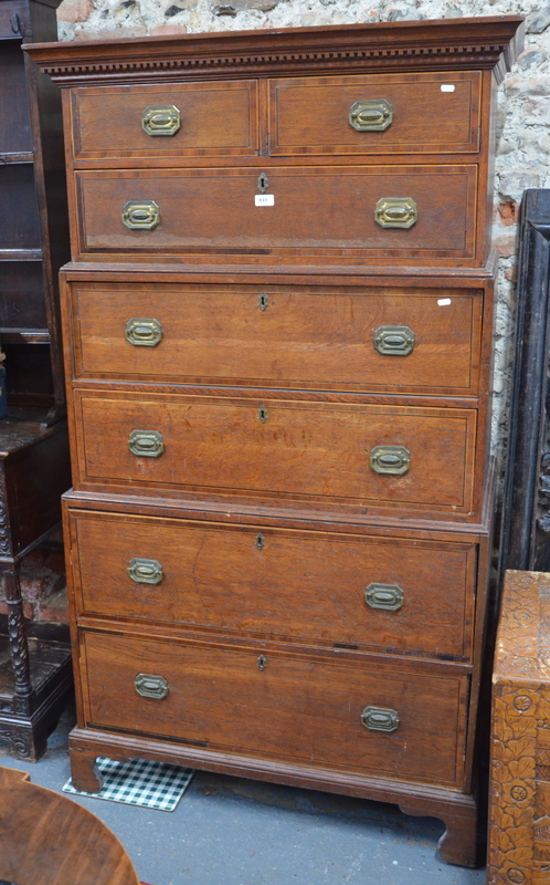 An unusual Georgian oak chest of two short and five long drawers with rosewood crossbanded fronts,