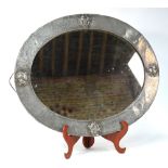 An Arts & Crafts hammered pewter ovoid well mirror with four stylised roundels in the Liberty