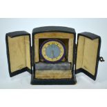 A small Art Deco gilt travel-clock with enamelled bezel and marble plinth, 6.2 x 6.