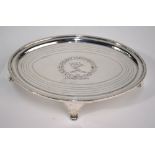 A George III silver bachelor teapot stand of elliptical form with engraved crest within concentric