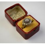 A circular grey star sapphire having rose diamonds around, in silver setting,