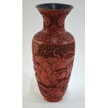 A Chinese red lacquer vase with trumpet neck decorated with Scholars and Acolytes in a rocky