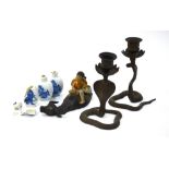 A pair of Indian, or other, metal candlesticks, each one designed as a rearing cobra,