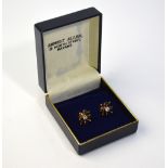 A pair of diamond and sapphire cluster earrings in the shape of a flower,