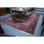 A Persian Heriz carpet, the large central blue medallion on red ground with stylised floral design,