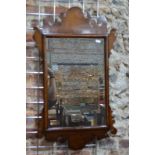 An antique mahogany fret cut and cushion framed wall mirror, retaining the original plate,