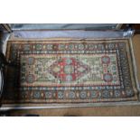 An Anatolian rug with central red medallion on camel ground within repeating border,