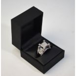 A contemporary diamond set ring, square cluster at top with diamond set shoulders,