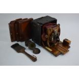 A morocco-bound mahogany quarter-plate camera with red leather bellows,