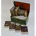 A quantity of cigarette silks to/w albums of trade cards and postcards,
