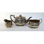 A George III Regency style three piece silver tea service with embossed decoration and gadrooned
