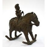 An Indian metal figure of a horseman, holding an edged weapon with his right hand,