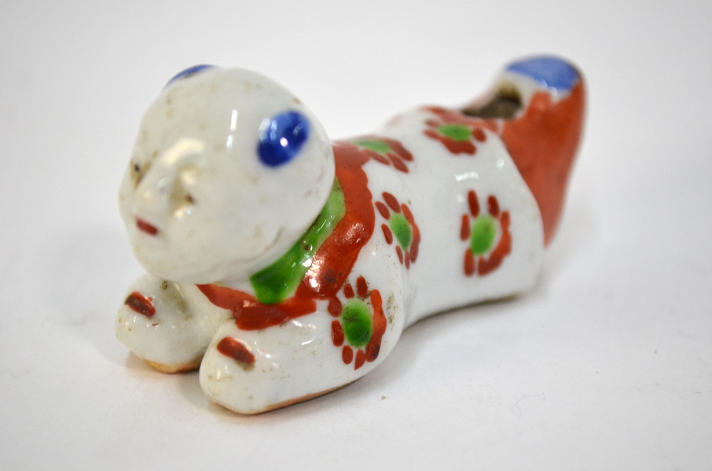 A scarce porcelain whistle designed as a recumbent karako with unglazed base; decorated in blue,