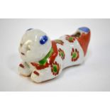 A scarce porcelain whistle designed as a recumbent karako with unglazed base; decorated in blue,