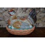 A Continental porcelain egg-container designed as a hen seated on her eggs, 21cm long,