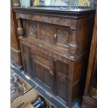 A 17th century oak court cupboard with heavy turned supports over carved and panelled joint frame