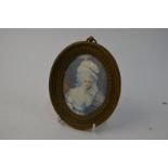 An oval portrait miniature on ivory of an 18th century lady of fashion, signed T.