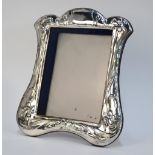 A modern silver-faced photograph frame in the Art Nouveau manner, embossed with daffodils,