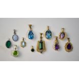 A collection of eleven stone set pendants, some 9ct, including amethyst, blue topaz,