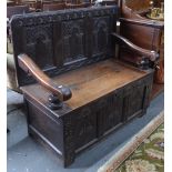 A part 17th/18th century carved oak box settle, formed from a coffer,