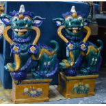 A large associated pair of glazed Buddhistic Lions; each one decorated with blue,