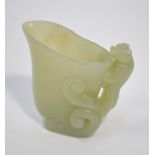 A green jade carved as an archaistic ewer or other vessel with mythological animal handle,