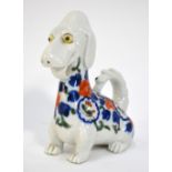 A Japanese Imari figure of a seated dog, decorated in underglaze blue, copper red and green, 12.