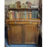 A Regency mahogany chiffonier having a moulded scroll supported shelf over a frieze drawer and pair