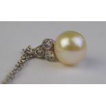 A cultured pearl pendant having three small diamonds below hanger,