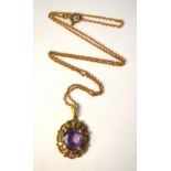 An oval amethyst claw set pendant in pierced and cast 9ct mount,