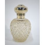 An ovoid cut glass scent bottle with silver hinged bun cover,